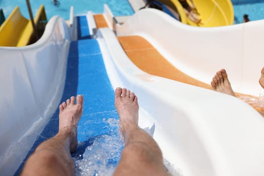 Man has fun on water slide in water park. Testing slides in pool concept