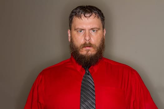 angry man wearing a red business shirt and tie