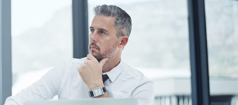 The extraordinary is out there, and I will achieve it. a corporate businessman looking thoughtful while working in an office