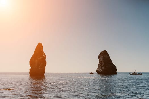 Two rocks stick out of the water in the middle of the turquoise sea. Scenic ocean views. High quality photo. Like in Iceland.