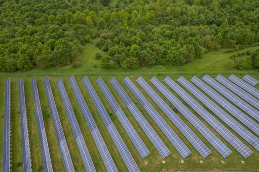 Renewable energy. Aerial shot drones fly over a photovoltaic power station. Group pf solar panels looking the sun for energy production.