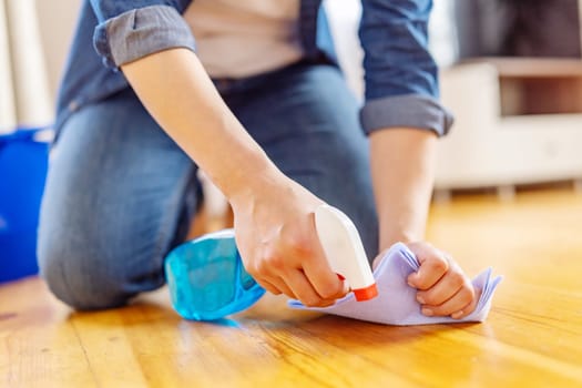 Woman is mopping floor with rag and detergent. Housekeeping and cleaning concept.