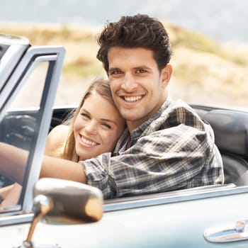 Happy to be driving together. An attractive young woman sitting next to her boyfriend in a sports car
