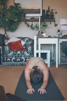 Yoga is good for your whole body. a young woman practising yoga at home