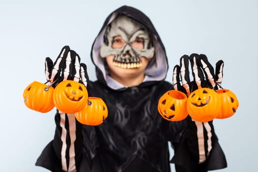 Happy Halloween. Cute little boy in a costume with many pumpkin baskets jack-o-lantern.