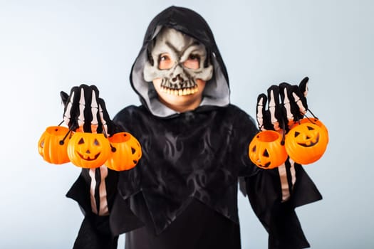 Happy Halloween. Cute little boy in a costume with many pumpkin baskets jack-o-lantern.