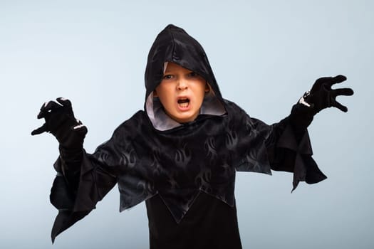 Happy Halloween. Portrait of an angry little boy in halloween costume with frightening gesture.