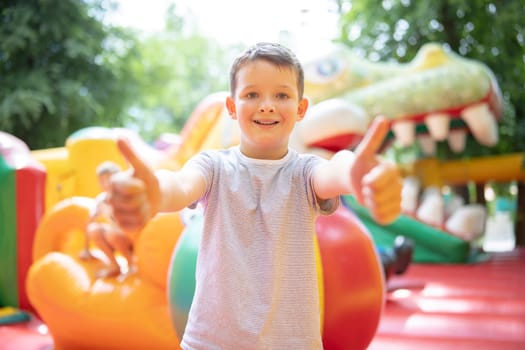 Happy boy having a lots of fun on a colorful inflate castle. Colorful playground. Activity and play center for kids.