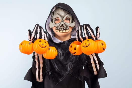 Happy Halloween. Cute little boy in a costume with many pumpkin baskets jack-o-lantern.
