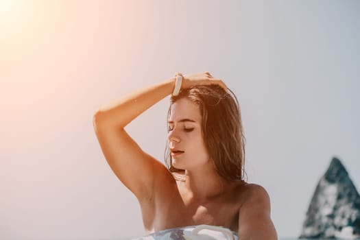 Woman summer sea. Happy woman swimming with inflatable donut on the beach in summer sunny day, surrounded by volcanic mountains. Summer vacation concept