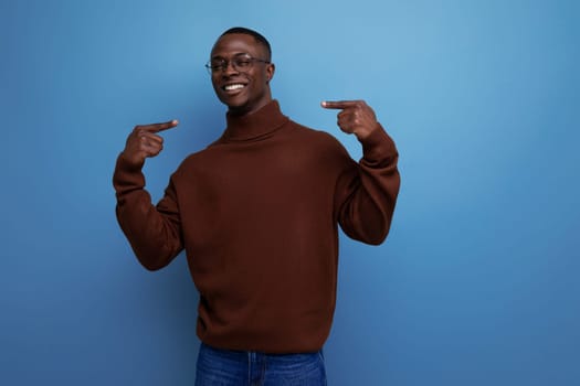 portrait of a successful young african man of model appearance in a brown sweater isolated with copy space background.
