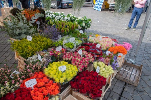 different flowers are sold in the market in baskets, with price tags, High quality photo