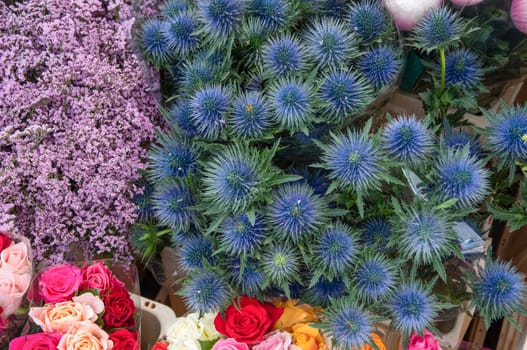 different flowers are sold in the market in baskets, with price tags, High quality photo