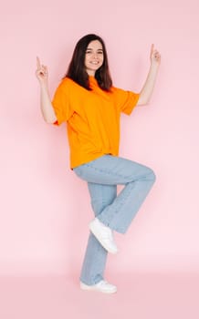 Celebratory Success: Beautiful Young Woman with Fists Raised in Joyous Victory, Marking the Completion of a Contract - Honoring a Lucrative Sales Promotion on Pink Background.