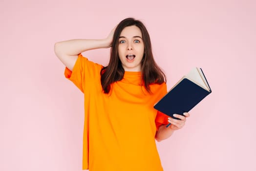 Captivating Reading Experience: Surprised Woman with Hand on Head, Engrossed in a Book with an Intriguing Genre - Fascination and Immersion Concept on Pink Background