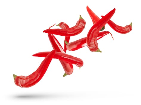 Pods of red hot peppers of various sizes and shapes fall on a white isolated background, casting a shadow. Fresh red pepper for insert in design or project, isolated on white, close up