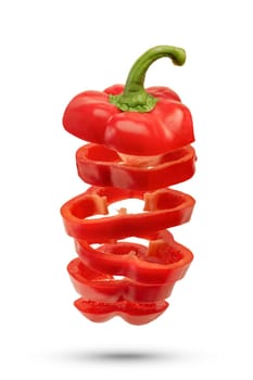 Red paprika or sweet pepper is cut into slices on a white isolated background. Slices of red paprika fall casting a shadow, pepper for insertion into a design or project.