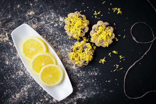 lemon cupcakes on a black background and a lemon on a plate