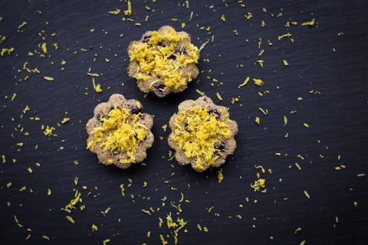 Three lemon cupcakes on a black background