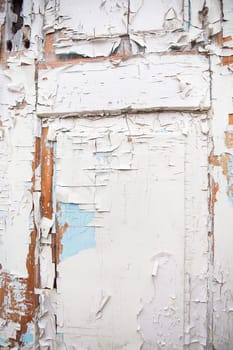 Very old wooden door with cracked white and blue paint.