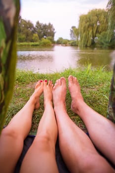 A small camping tent on the lake, a night's lodging and the feet of a young couple.