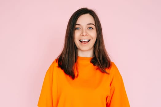 Surprised Delight: Cheerful Woman Expressing Amazement with Open Mouth - Joyful Reaction and Positive Energy on Vibrant Pink Background