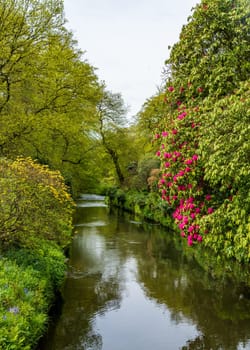 View up a valley in a natural park or gardenwith calm river in the North of England