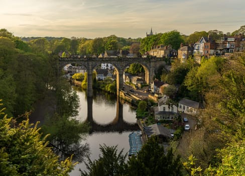 Stone viaduct over River Nidd at Knaresborough with rowing boats by riverbank