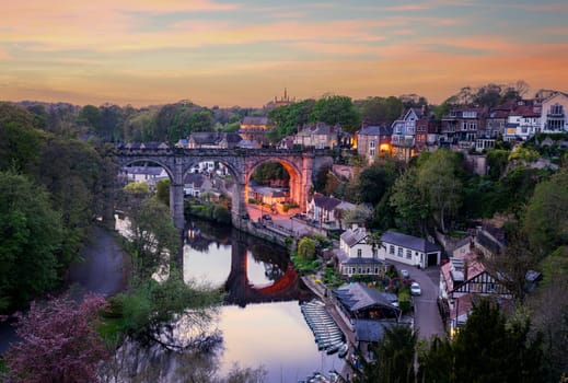 Stone viaduct over River Nidd at Knaresborough with rowing boats by riverbank