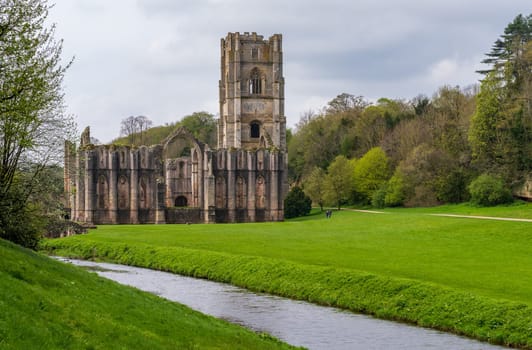 Detail of the ruins of Fountains Abbey in Yorkshire, United Kingdom in the spring with River Skell flowing past