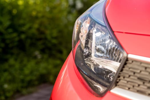 Headlights and hood of sport red car with silver stars