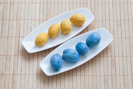 painted yellow and blue nuts on plates.