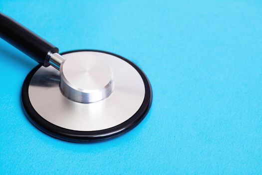 Part of a stethoscope on a blue background close up