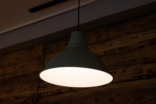 Bright white light bulb with a white lamp in the dark close up