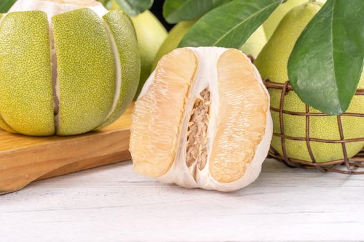Fresh peeled pomelo, pummelo, grapefruit, shaddock on bright wooden table background. Seasonal fruit for Mid-Autumn Festival, close up, copy space.
