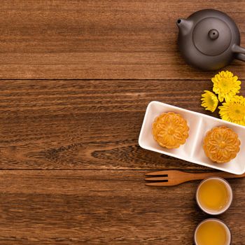 Mid-Autumn Festival holiday concept design of moon cake, mooncakes, tea set on dark wooden table with copy space, top view, flat lay, overhead shot