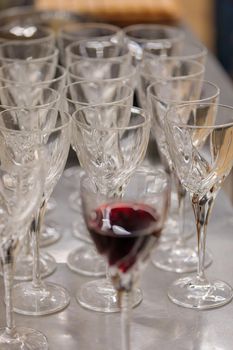 Empty wine glasses on the table. One glass of red wine. A festive event.