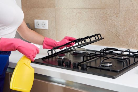 Cleaning a gas stove with kitchen utensils, household concepts, or hygiene and cleaning
