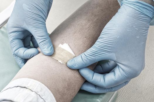 Nurse doing blood test from vein. Covid testing concept. green tonning. Using medical tape