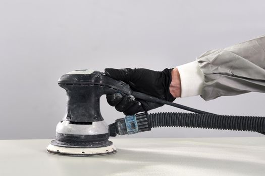 Auto mechanic buffing and polishing car in auto repair shop