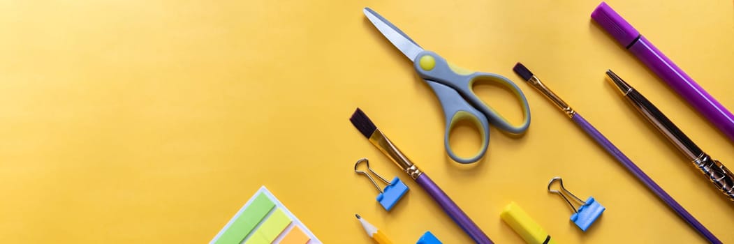 Back to school concept. Colorful stationary school supplies on yellow background, space or text flat lay
