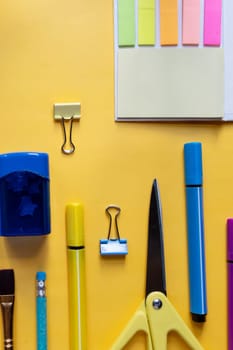 Back to school concept. Colorful stationary school supplies on yellow background, space or text flat lay