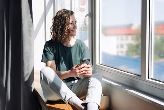 Homebound Serenity: Young Woman Embraces Connectivity and Tranquility, Finding Relaxation and Connection Through Technology During Lockdown.