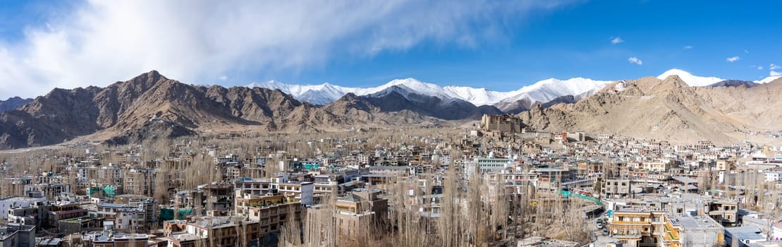 Leh, India - April 02, 2023: Panoramic view of Leh with the royal palace and snow capped mountains in the background
