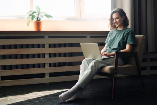 Efficiency and Flexibility: Young Woman Embraces Remote Work and Study, Utilizing Laptop at Home. Versatile Lifestyle of Freelancing, Business, and Self-Determination in a Cozy Home Environment