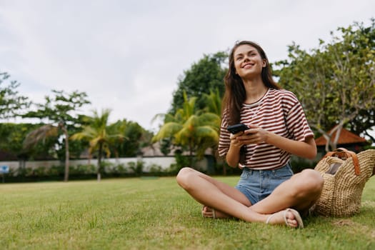 healthy woman happy nature blogger phone talking grass talk cell park spring lifestyle smartphone application network green smiling young walk tree palm