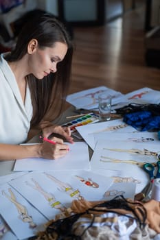 Woman drawing sketches of swimwear and underwear in watercolor