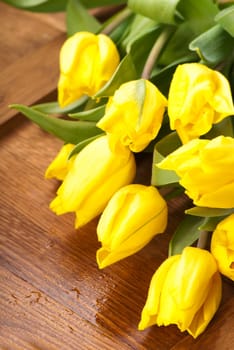 Bouquet of yellow tulips on wooden boards