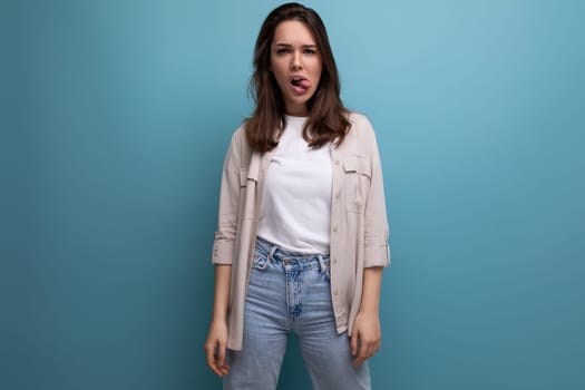 cute 25 year old female person in casual look posing on blue background.