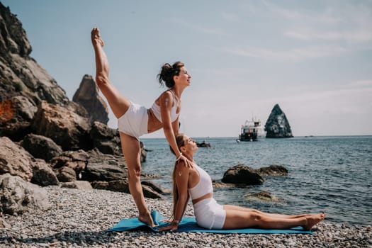 Woman sea yoga. Back view of free calm happy satisfied woman with long hair standing on top rock with yoga position against of sky by the sea. Healthy lifestyle outdoors in nature, fitness concept.